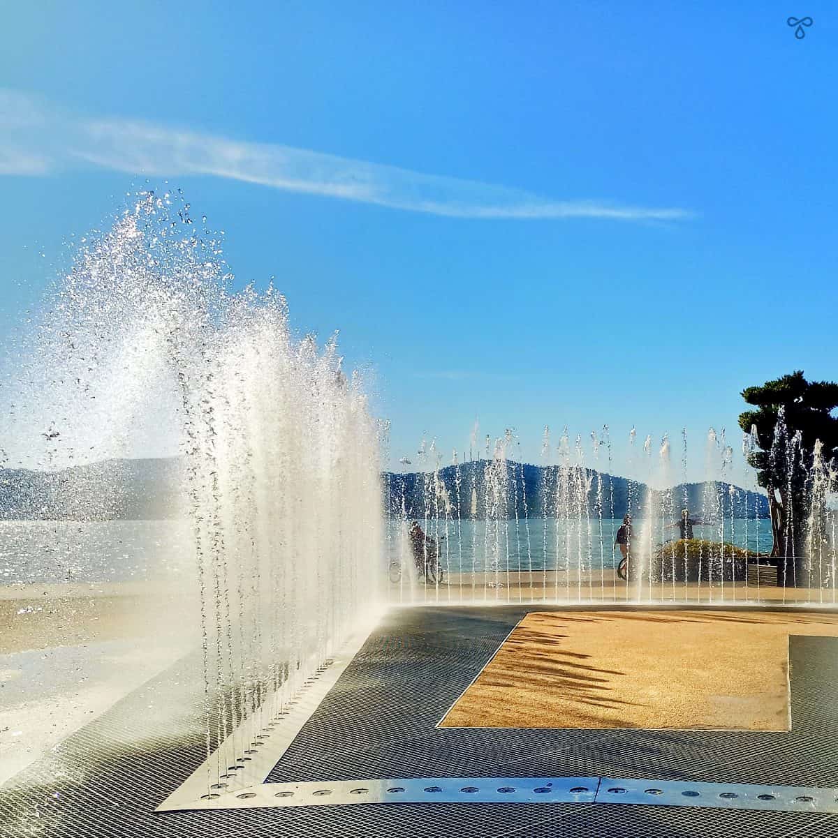 Fountains in Fethiye Bey Park, Fethiye. The sea and coastline is in the background.