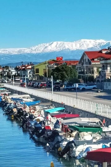 Motor boats moored up in Fethiye with snowy mountains in the background