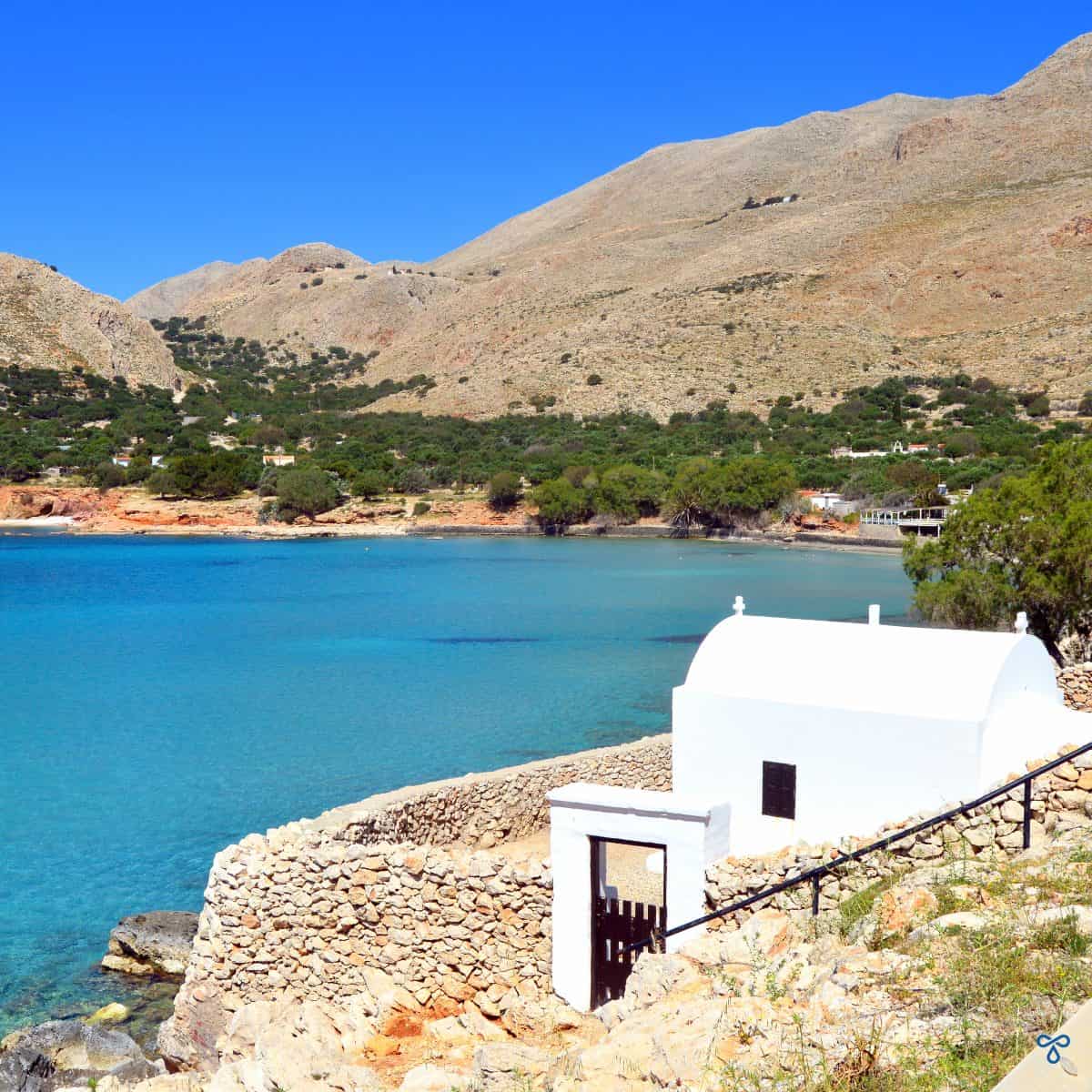 A white chapel on the roadside, overlooking the calm bay.
