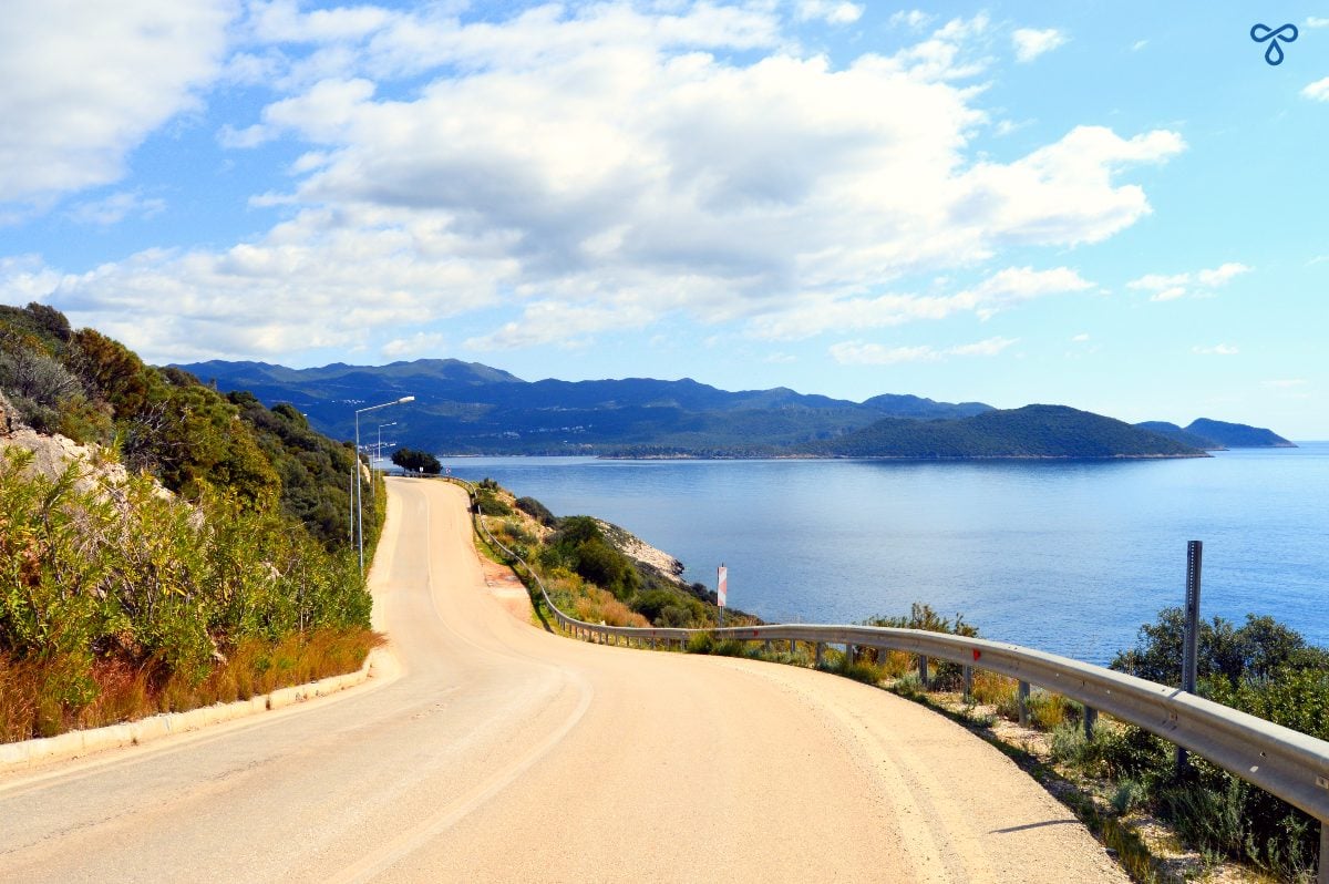A road leading off into the distance with open sea to the right.