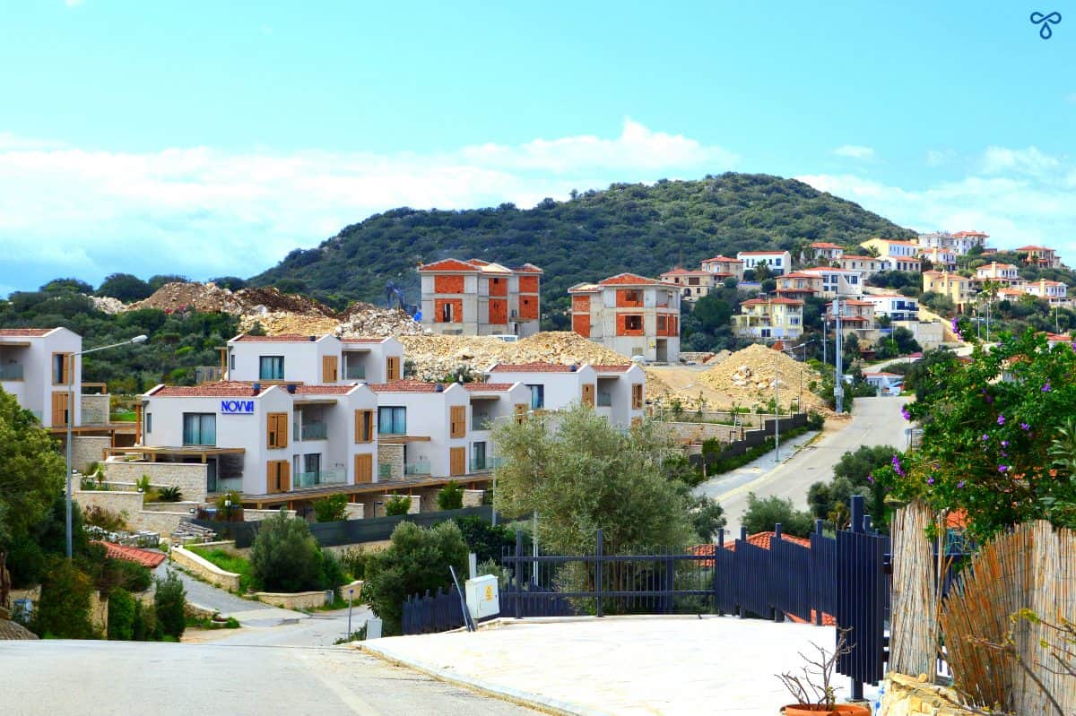A steep uphill road with homes being built on the hillside to the left.