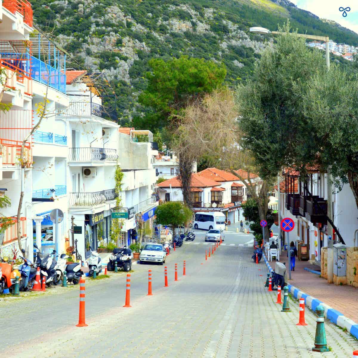 A steep downhill road in Kaş, lined with whitewashed shops and pension accommodation.