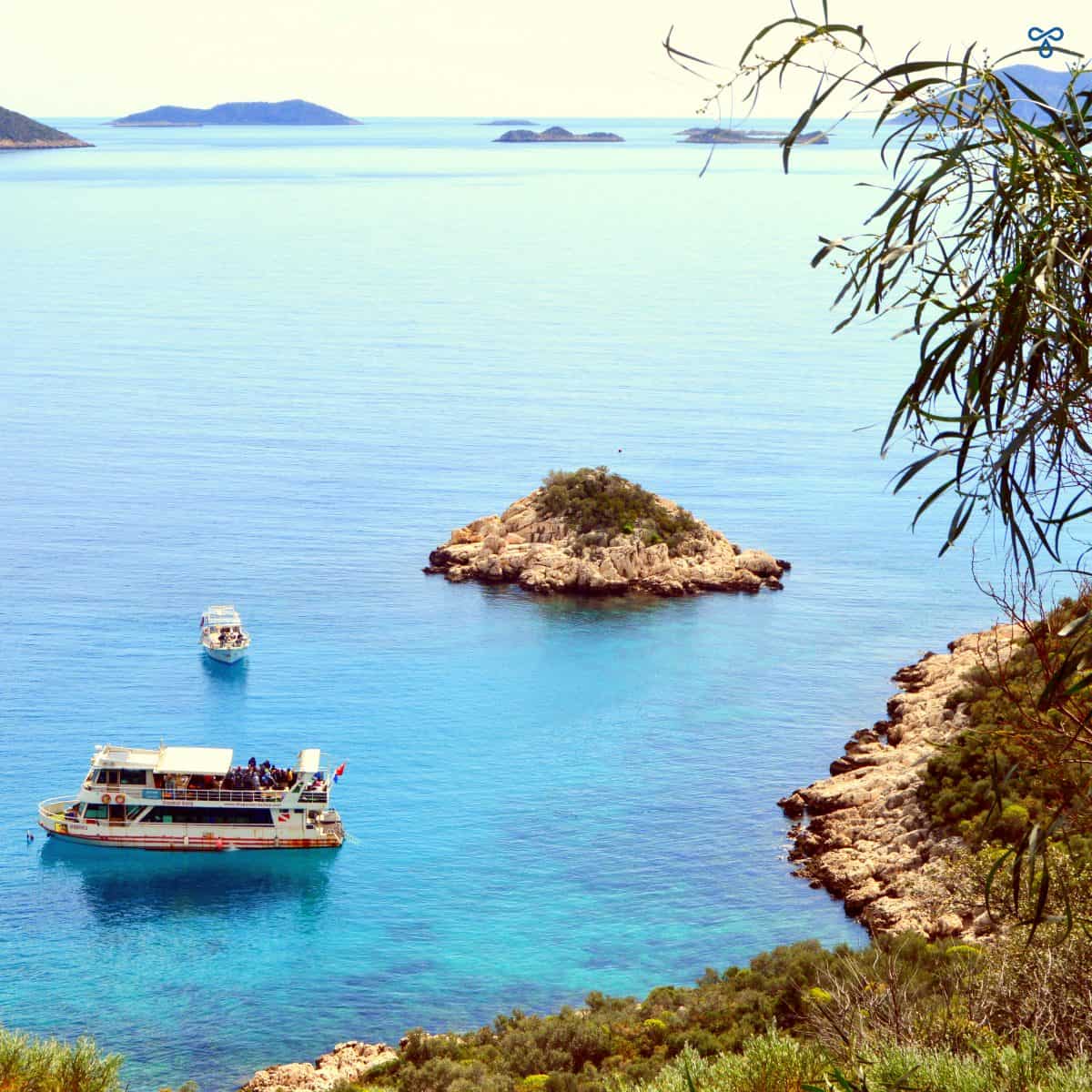 Looking down at the sea from above where there is a boat with scuba divers.