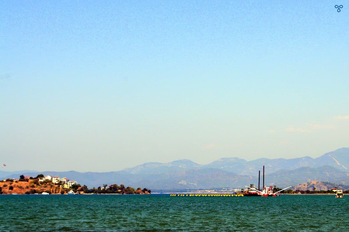 A distant vessel in the sea in Fethiye. Island and mountains are in the background.
