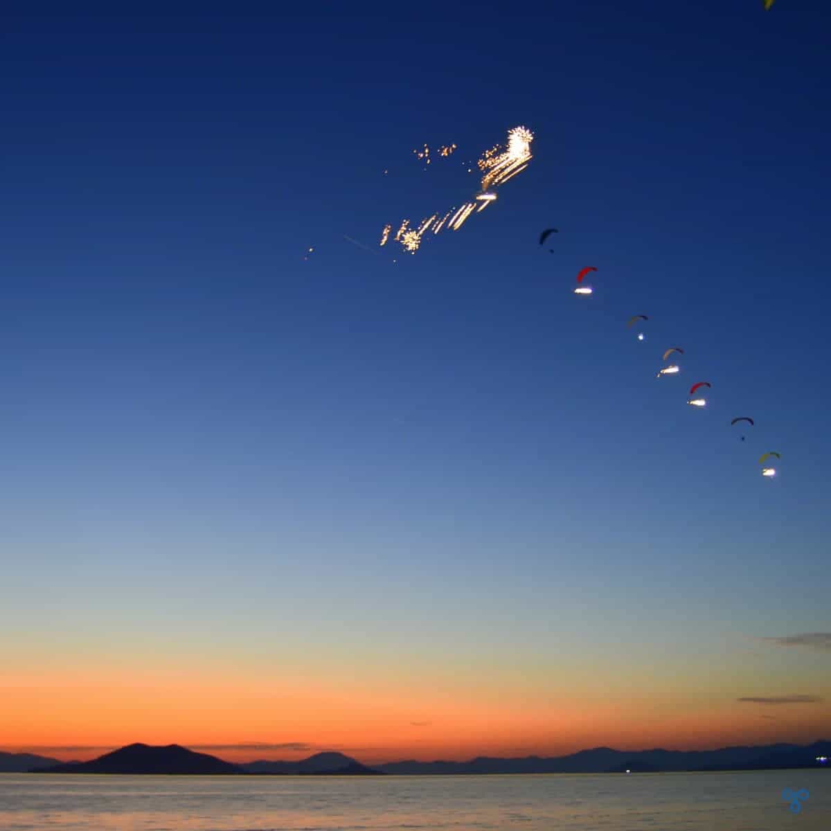 Paramotors in formation in the night sky. LED lights are illuminating the team.